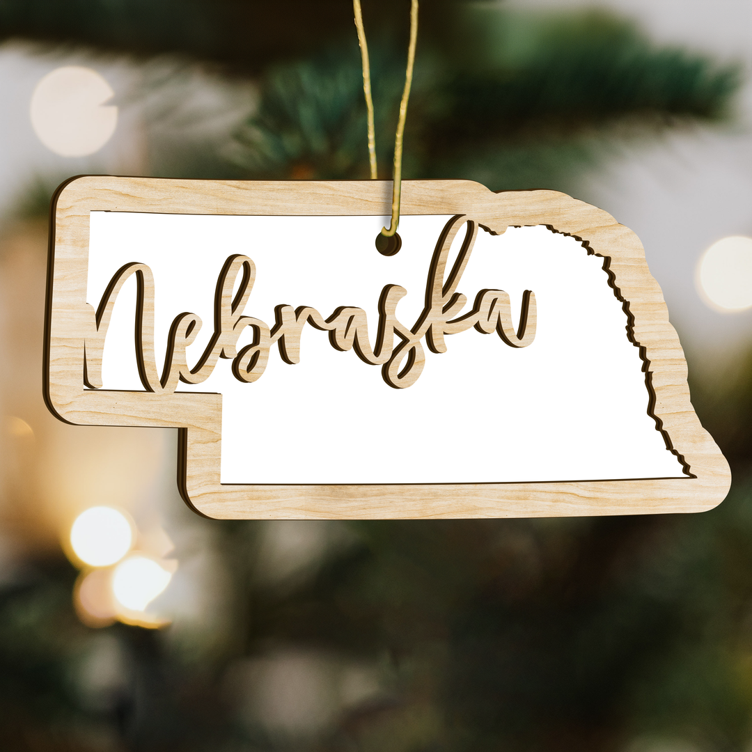 Nebraska state-shape wood ornament on a tree, blank photo panel for your own picture
