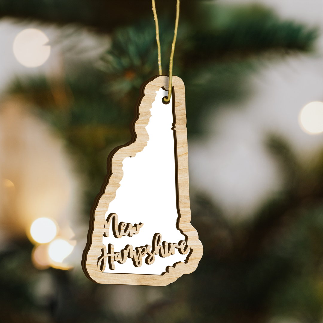 New Hampshire state-shape wood ornament on a tree, blank photo panel for your own picture