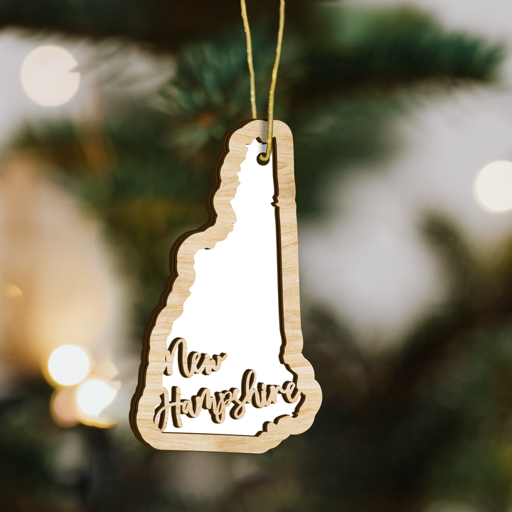 New Hampshire state-shape wood ornament on a tree, blank photo panel for your own picture