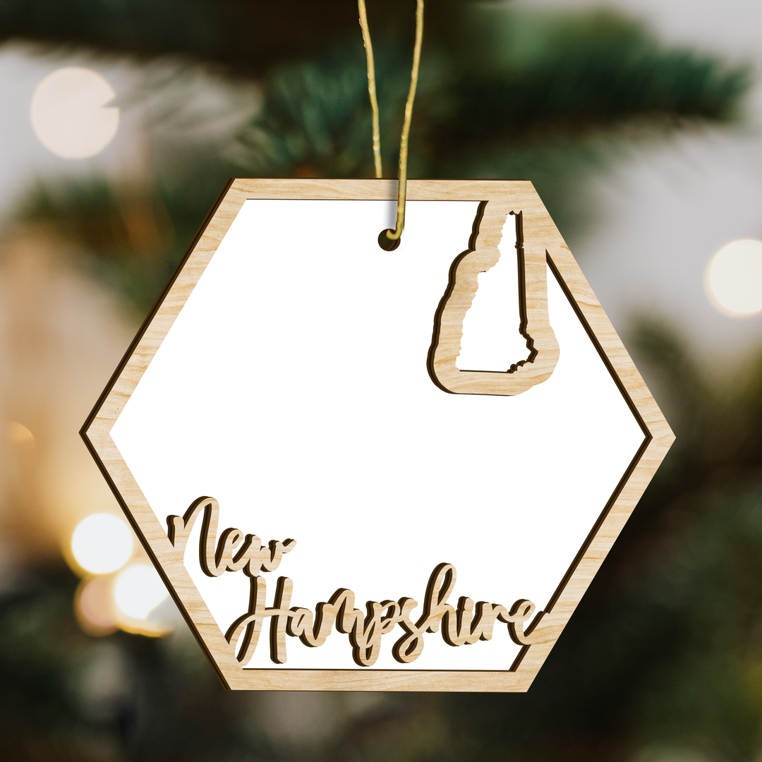 New Hampshire hexagon wood ornament on a tree, blank photo panel with the state outline