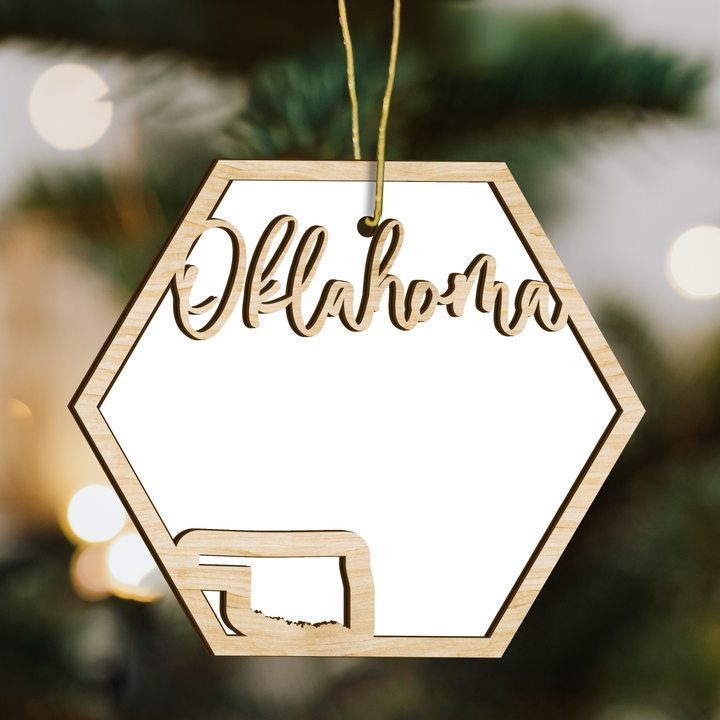 Oklahoma hexagon wood ornament on a tree, blank photo panel with the state outline