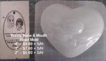 Clear plastic heart mold with a bunny nose and mouth pressed into the centre