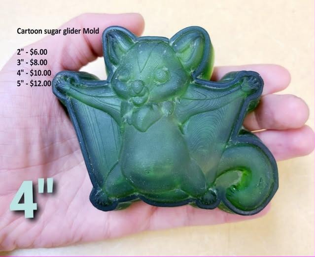 Cartoon sugar glider mold cast in green, membrane spread wide, held in a hand