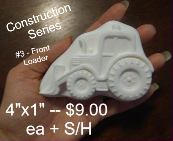 Front loader cast from the construction vehicle series mold, held in a hand at four inches