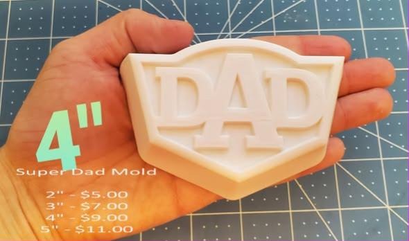 Super Dad mold, the word DAD in a superhero-style shield, held in a hand at four inches