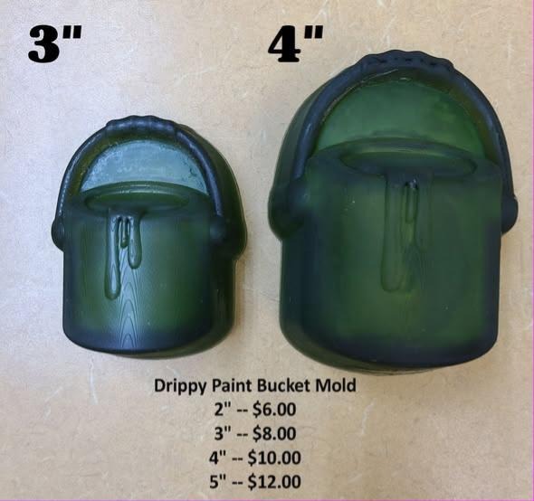 Two green casts of a paint bucket with a handle and paint dripping down the side