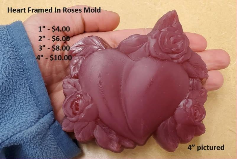 Heart mold with a smooth puffed heart ringed by open roses and pointed leaves.