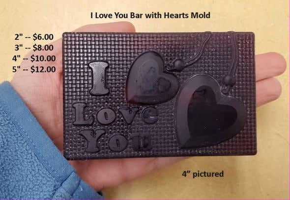 Rectangular I Love You bar cast in chocolate, raised letters beside three hearts on woven texture