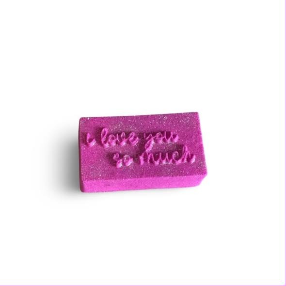 Magenta glitter bar with i love you so much pressed into the top face in loose handwritten script