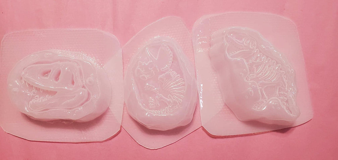 The three clear plastic dino fossil molds laid side by side