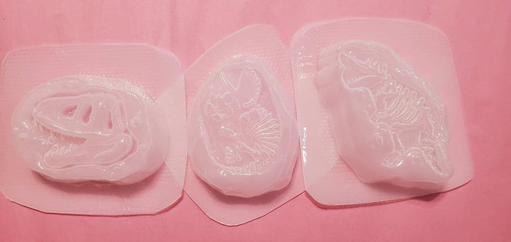 The three clear plastic dino fossil molds laid side by side