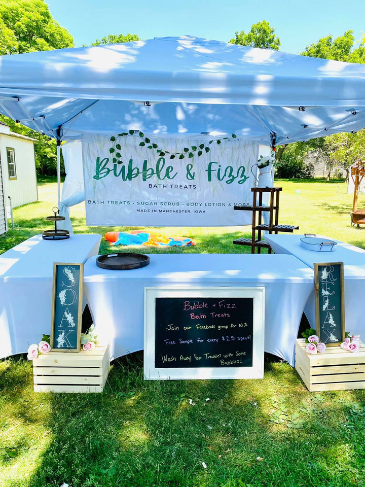Bubble and Fizz Bath Treats banner across the front of a canopy at an outdoor craft stall.