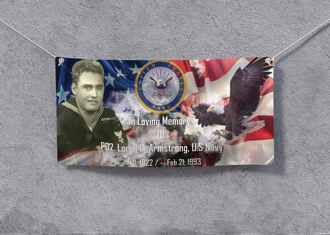 Vinyl memorial banner hung by cord on a grey wall, portrait and flag design with corner grommets.