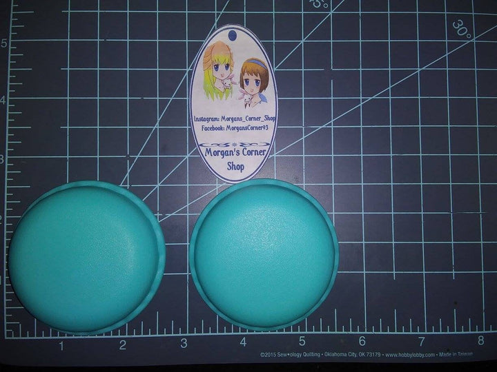 Two teal macaron casts on a cutting mat beside a Morgan&