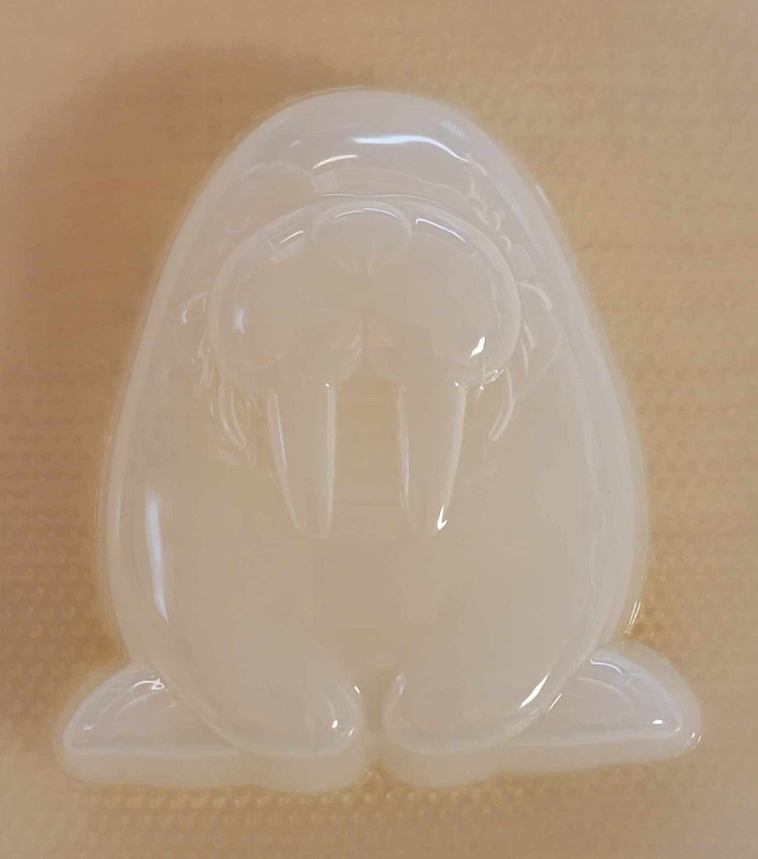 Clear plastic walrus mold showing the whiskered muzzle, tusks and tucked-in flippers.