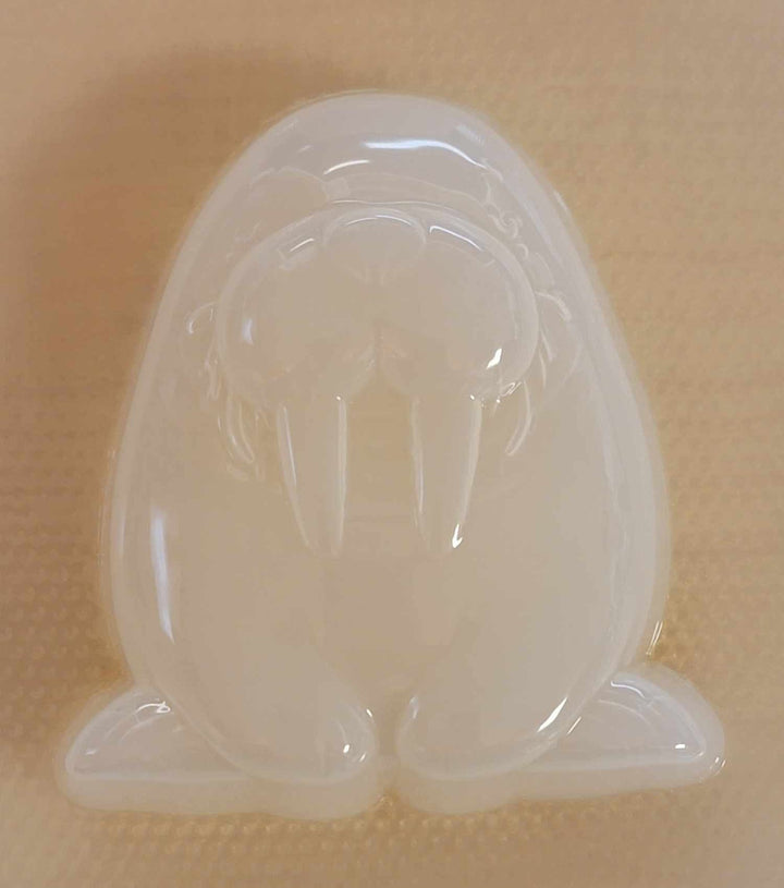 Clear plastic walrus mold showing the whiskered muzzle, tusks and tucked-in flippers.