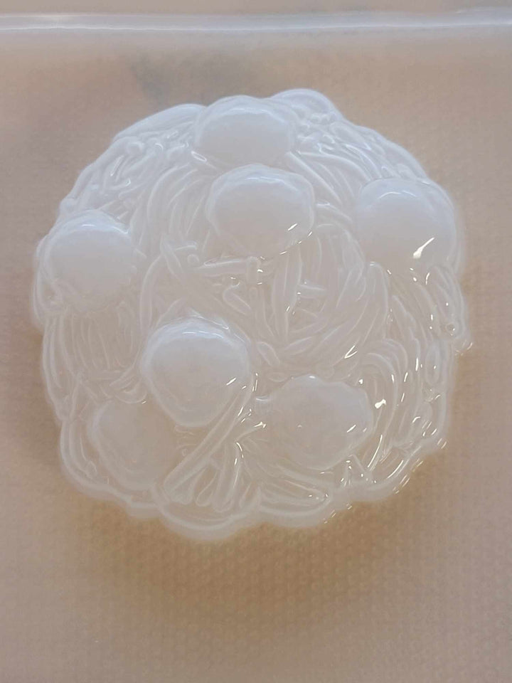 Clear plastic spaghetti and meatballs mold, noodle strands spilling over the round rim.