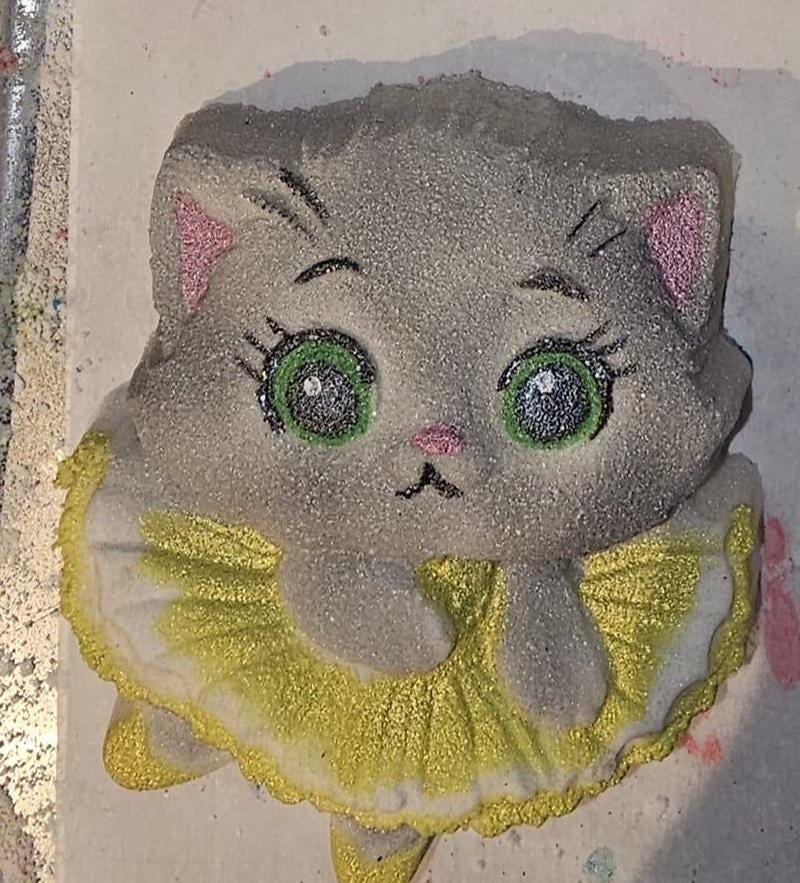 Ballerina kitten cast in grey glitter with green eyes, pink nose and a yellow ruffled tutu.