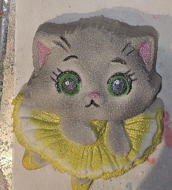 Ballerina kitten cast in grey glitter with green eyes, pink nose and a yellow ruffled tutu.