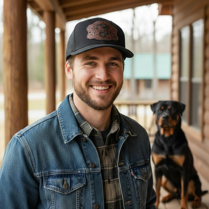 Man on a porch wearing the Rottweiler portrait cap with a Rottweiler sitting beside him.