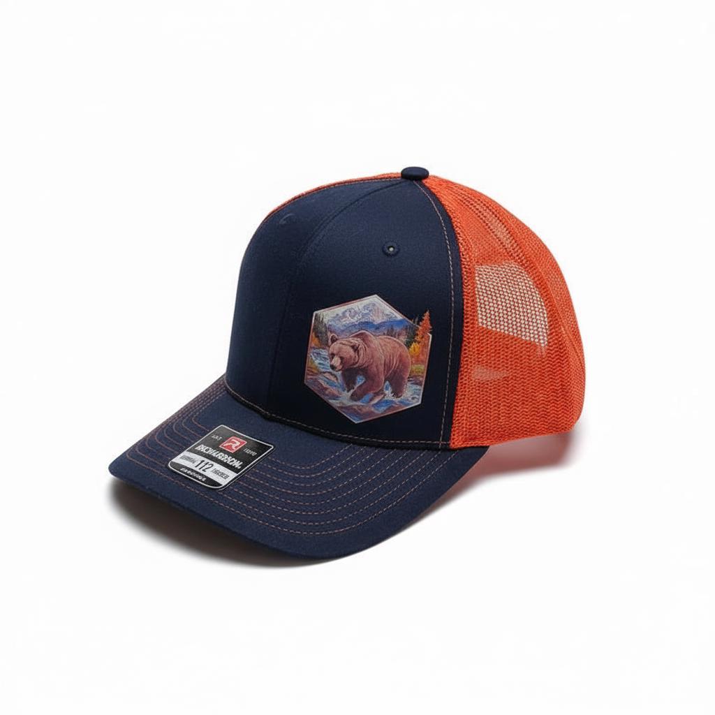 Navy cap with orange mesh back and the hexagonal bear and mountain leatherette patch.