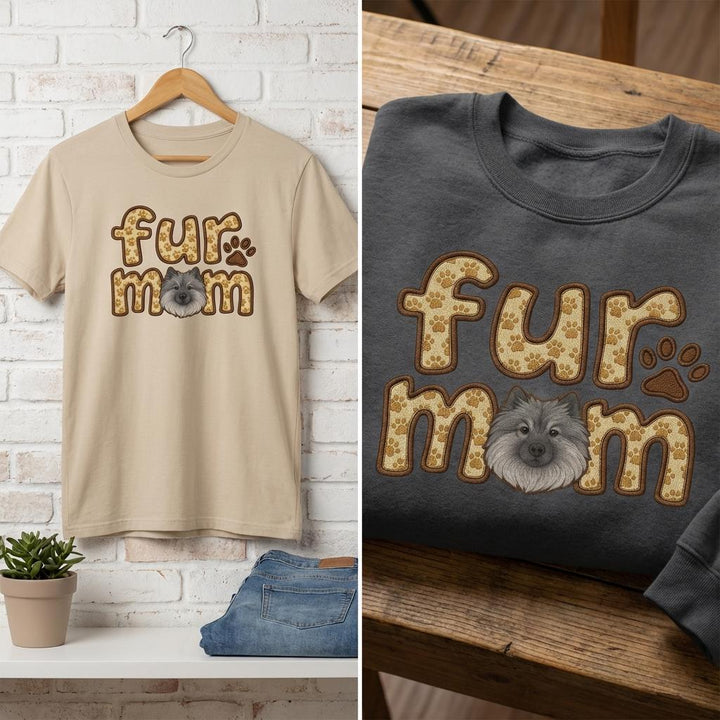 Sand tee on a hanger and a dark grey sweatshirt, both carrying the fur mom Keeshond design.