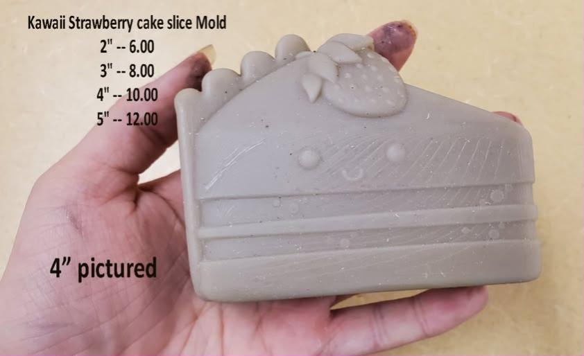 Kawaii cake slice mold, a layer cake wedge with a smiling face, piped frosting and a strawberry.