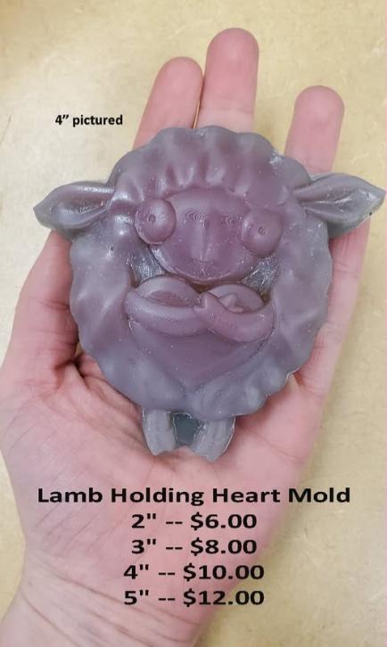 Cast mold of a curled woolly lamb hugging a plump heart with tiny hooves below