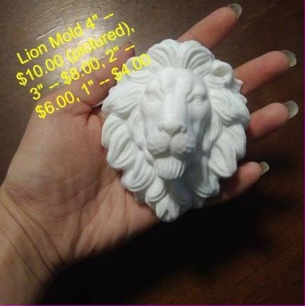 White lion head casting with a deeply carved overlapping mane and broad muzzle, resting in a hand