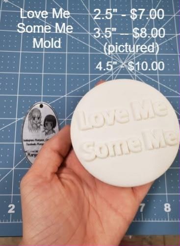 White round casting with the words Love Me Some Me raised across the face, held in a hand