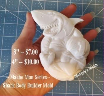 White cast of a muscular shark bodybuilder flexing both arms, held in a hand.