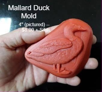 Terracotta mallard duck cast held in a hand, bill tucked down and wing feathers detailed.