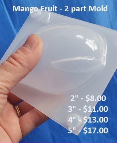 Clear silicone two-part mango mold held to the light, showing a deep plump fruit cavity with corner nubs.