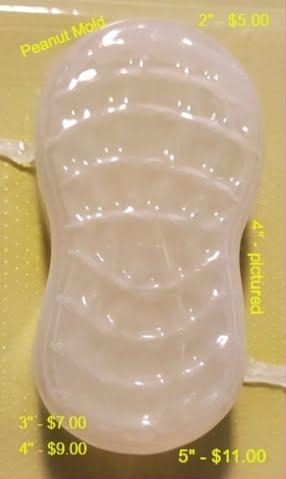 Clear plastic peanut in-shell mold with a pinched waist and ribbed shell texture.