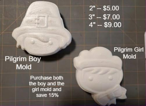 Cast pilgrim molds side by side, a boy in a buckled hat and a girl in a bonnet