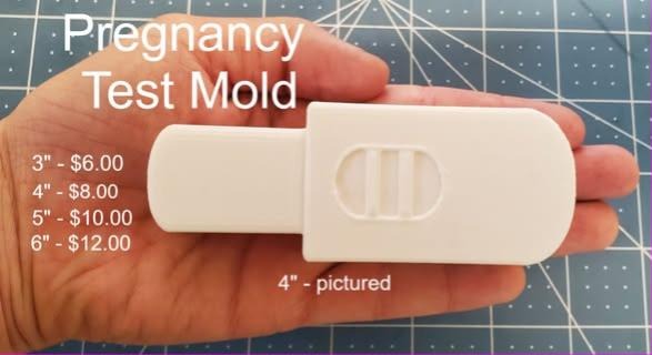 Cream cast pregnancy test wand with a rounded cap and an oval window showing two lines