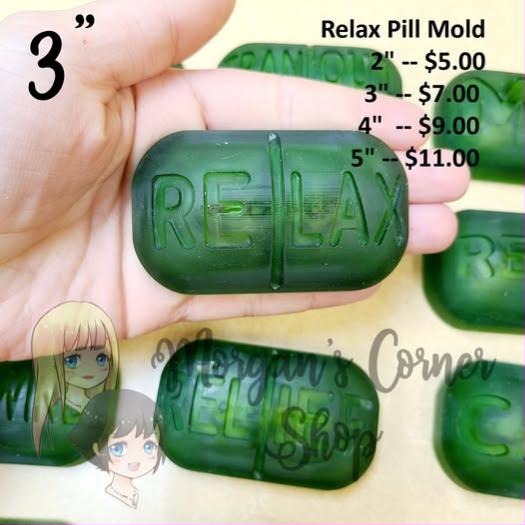 Green cast pill mold, rounded rectangle caplet with a centre seam and RELAX across the face.