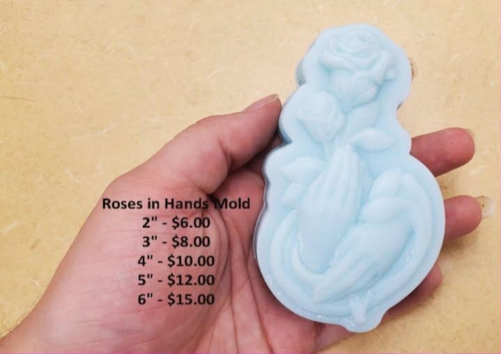 Mold of two cupped hands cradling a bunch of roses with buds, long pointed leaves and stems.