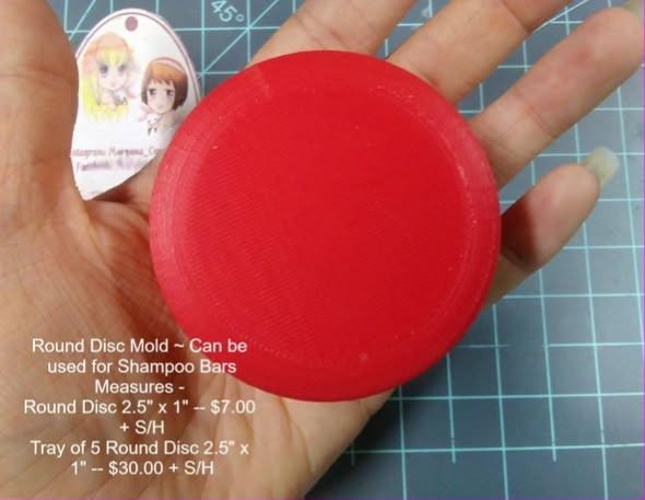 Solid red cast round disc puck with a flat top and straight sides, held in an open hand