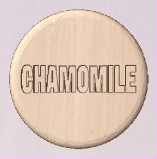 Round pale wood-tone shower tablet cast with CHAMOMILE in hollow block capitals
