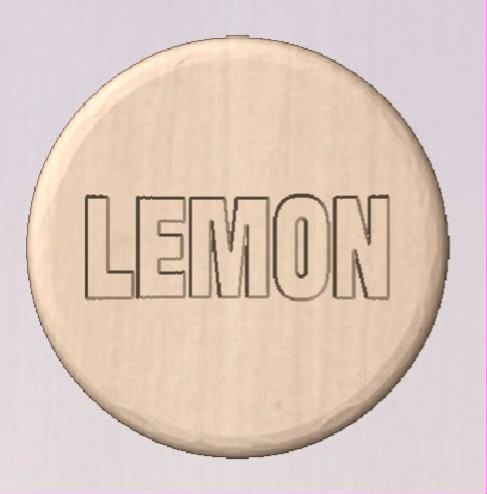 Round shower tablet mold cast in pale wood tone with LEMON engraved in block capitals.