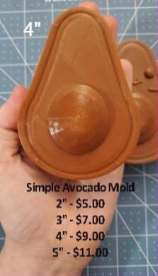 Tan flat-backed avocado half casting with a domed stone in the centre, held in a hand