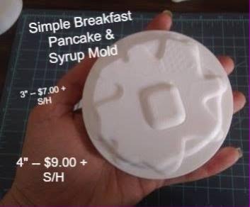 White pancake mold with a square butter pat in the centre and syrup pooling out to the rim.