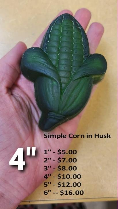 Dark green cast of an ear of corn with rows of kernels and husk leaves peeling back to points.