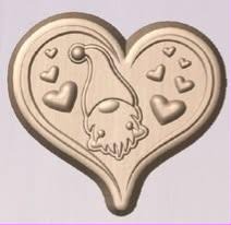 Tan heart-shaped casting with a long-hatted gnome inside and small hearts scattered around him
