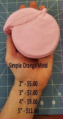 Pink casting of a round orange with a dimpled stem well and one pointed leaf folded over the top