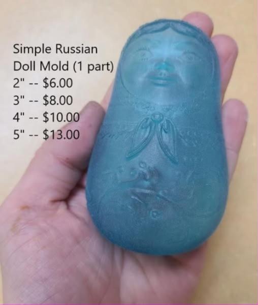 Translucent teal matryoshka doll cast with a scalloped headscarf and a floral front panel.