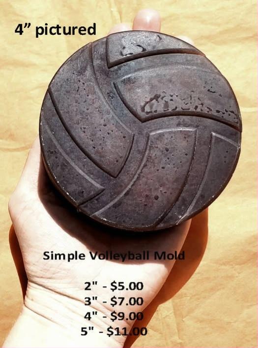 Dark speckled volleyball cast held in a hand, with classic curved panel grooves around it.
