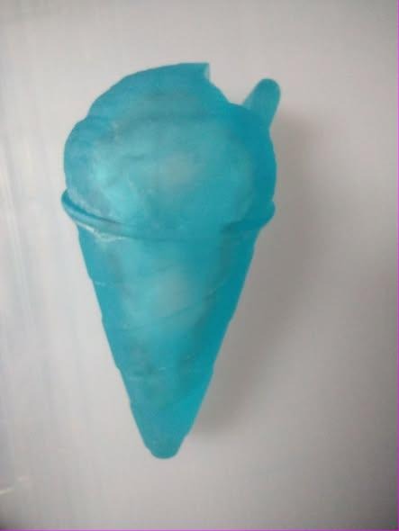 Translucent teal snow cone casting with a rough mound of shaved ice over a tapering cone