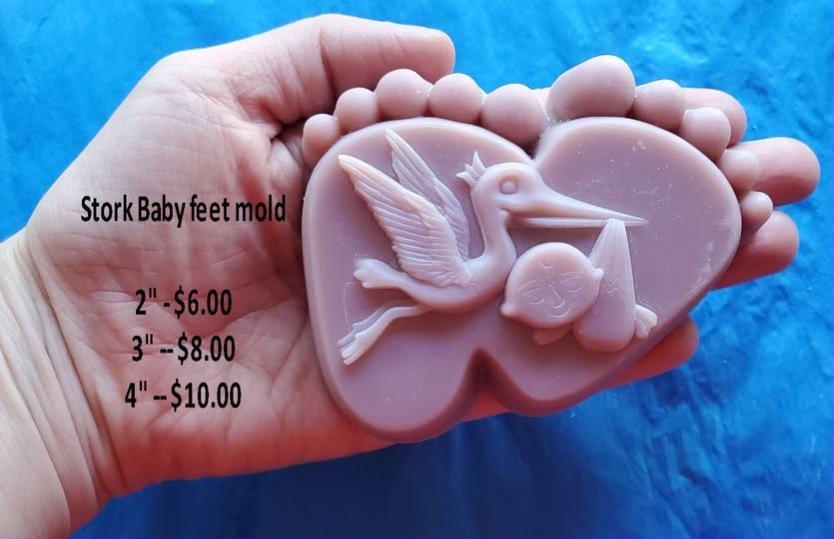Baby feet shaped mold holding a stork in flight with a bundle and a swaddled baby beside it.